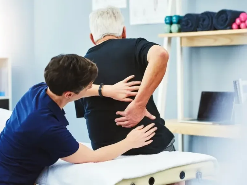 Physical therapist assessing a patient's low back movement and mobility