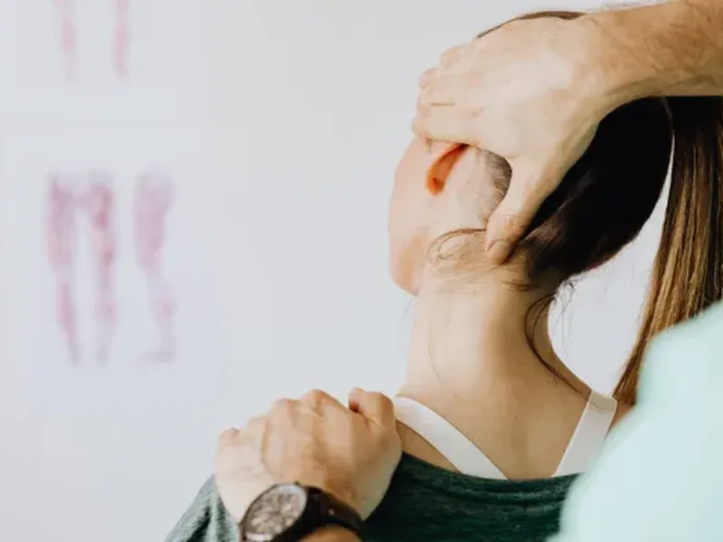 Physical therapist assessing a patient's neck rotation and mobility