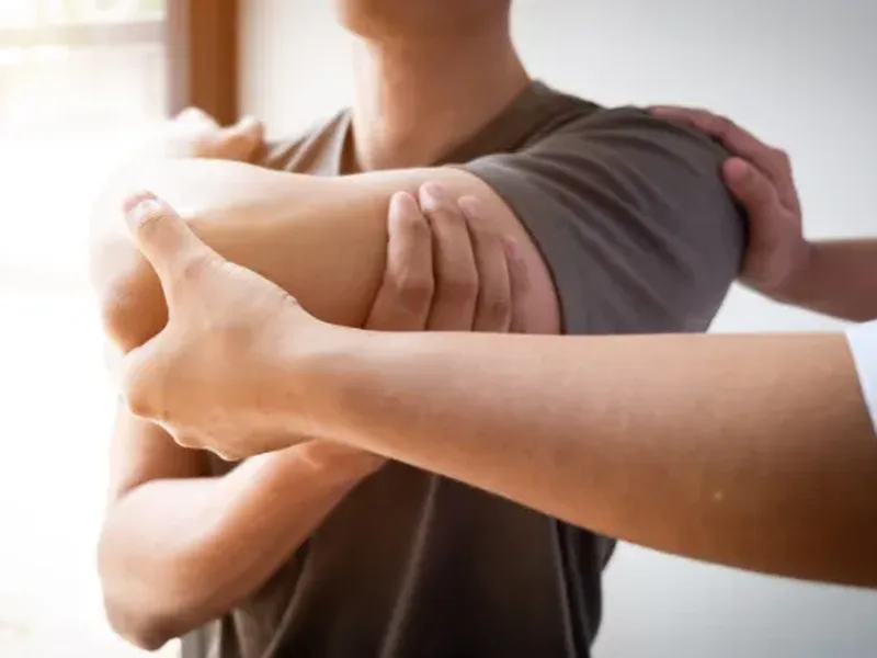 Physical therapist assessing a patient's shoulder strength and rotator cuff mobility