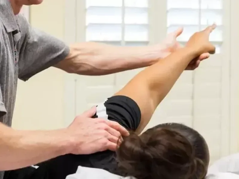 Physical therapist assessing a patient's shoulder range of motion