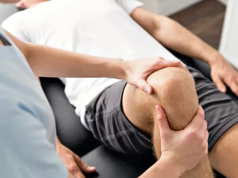 Physical therapist performing joint mobilization on a patient's knee
