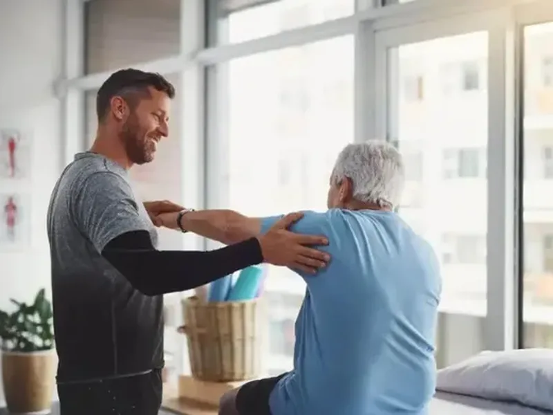 Physical therapist guiding a patient through a shoulder mobility exercise