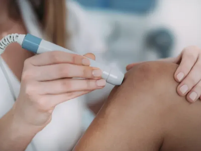 Physical therapist applying manual trigger point pressure to a patient's shoulder
