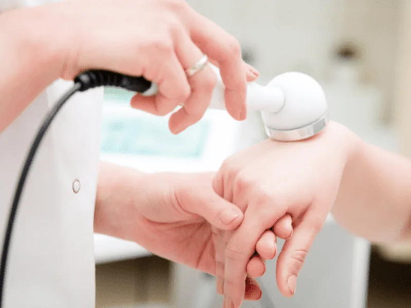 Physical therapist applying therapeutic ultrasound to a patient's knee